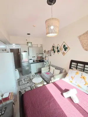 a bedroom with a bed and a living room at Sophia's Place Beacon Amorsolo in Manila