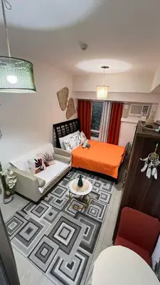a living room with a bed and a couch at Sophia's Place Beacon Amorsolo in Manila