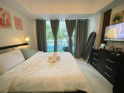 a teddy bear sitting on a bed in a bedroom at Azure Urban Resort Residences - stayCAOtion in Manila