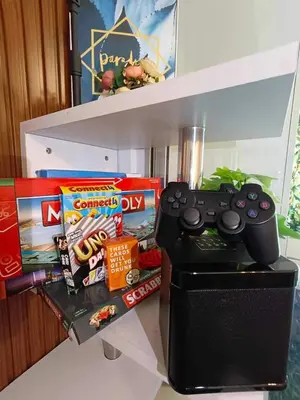 a video game controller sitting on a shelf with snacks at Azure Urban Resort Residences - stayCAOtion in Manila