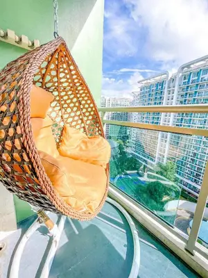 a hanging hammock on a balcony with a view of a city at Azure Urban Resort Residences - stayCAOtion in Manila