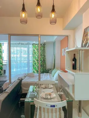 a living room with a table and a bed at Azure Urban Resort Residences - stayCAOtion in Manila