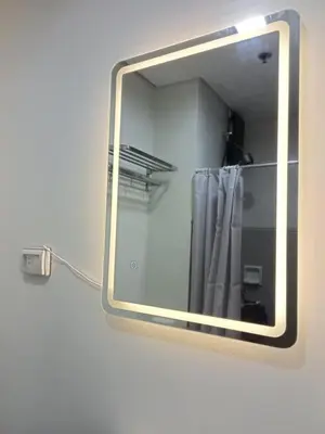 a mirror hanging on a wall with a shower curtain at SM HOME Spring Residences Staycation and Condotel in Manila