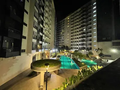 a view of a building with a swimming pool at night at SM HOME Spring Residences Staycation and Condotel in Manila