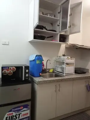 a small kitchen with a sink and a microwave at Spring Residences 2BR R&D Staycation and Condotel in Manila