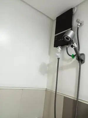 a shower in a corner of a room at Spring Residences 2BR R&D Staycation and Condotel in Manila