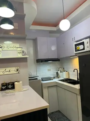 a kitchen with white cabinets and white appliances at Lucky 7 Suites in Manila