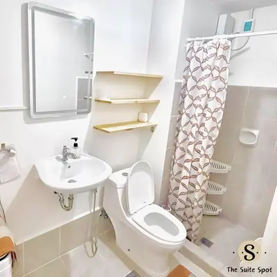 a white bathroom with a toilet and a sink at Condo in Las Piñas- The Suite Spot Alabang in Manila
