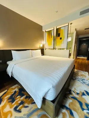 a large white bed in a bedroom with a rug at Hotel Residences near Makati in Manila