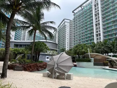 a umbrella sitting on a beach next to a swimming pool at Azure Urban Resort Residences Maui Tower in Manila