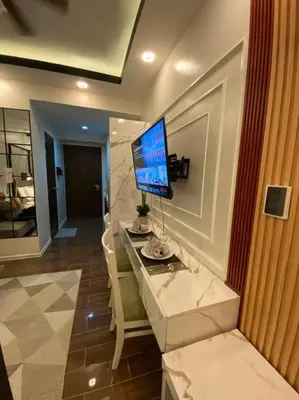 a room with a desk with a television on a wall at AIR RESIDENCES Makati Netflix plus 200 mbps digital door lock in Manila