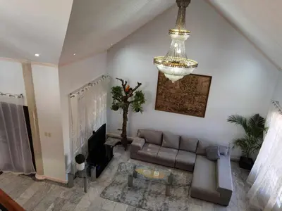 a living room with a couch and a chandelier at Tropical house in Manila