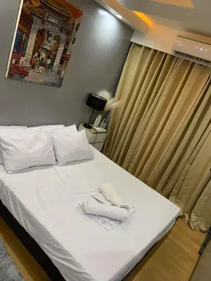 a bedroom with a bed with white towels on it at Aura Suites in Imus