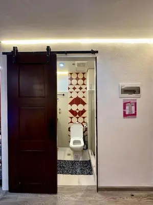 a bathroom with a toilet and a wooden door at Prime End Sunset View Unit in Makati in Manila