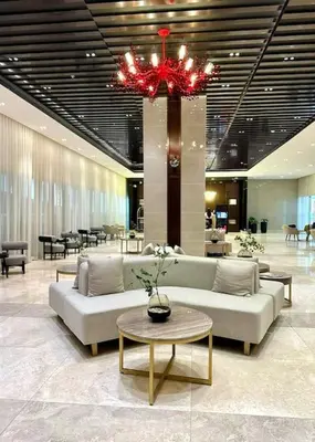 a lobby with couches and a table and a chandelier at Prime End Sunset View Unit in Makati in Manila