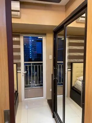a room with sliding glass doors and a balcony at Cozy Staycation by Ayumi in Manila
