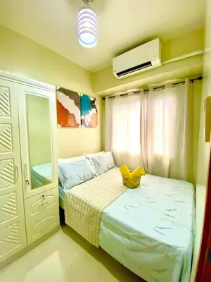 a bedroom with a bed with a yellow shoe on it at Comfystay at Shore Residences in Manila