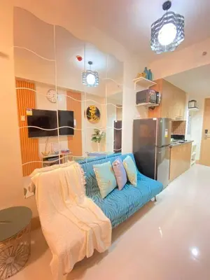 a living room with a blue couch in a kitchen at Comfystay at Shore Residences in Manila