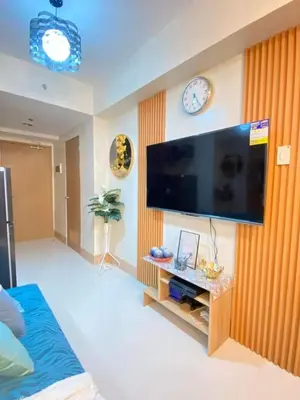 a living room with a large flat screen tv on a wall at Comfystay at Shore Residences in Manila