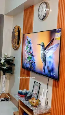 a television with a picture of a bird on a wall at Comfystay at Shore Residences in Manila