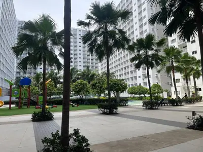 a park with palm trees in front of tall buildings at Shore Family Suite 2 beds for 4 pax TV Netflix WiFi Near MOA NAIA 9116 in Manila