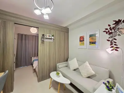 a living room with a couch and a table at 1BR Condotel with Balcony at FAME Residences #FM62 in Manila