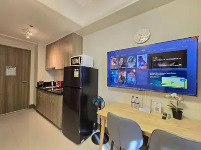 a kitchen with a table and a black refrigerator at 1BR Condotel with Balcony at FAME Residences #FM63 in Manila