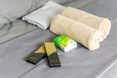 two awards on a bed with a sock and a book at 2Bedroom 2Bath near moa with Balcony facing pool in Manila