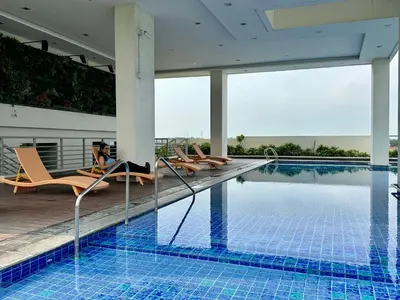a swimming pool with lounge chairs next to a building at The Verdin in General Trias