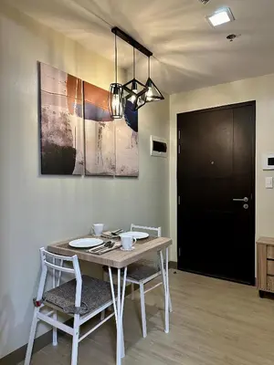 a dining room with a table and chairs and a black door at The Verdin in General Trias