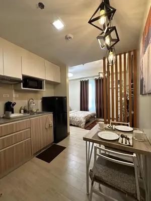 a kitchen and living room with a table in a room at The Verdin in General Trias