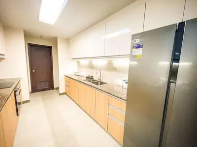 a kitchen with a stainless steel refrigerator and wooden cabinets at Luxury 1BR beside Okada Manila in Manila