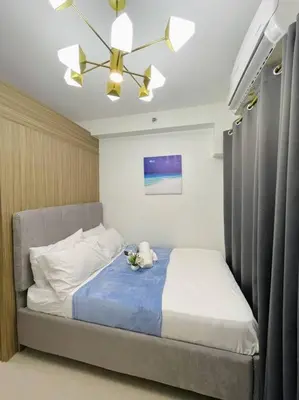 a bedroom with a bed with a blue blanket at Ocean Room 677 Shore 2 Tower 3 MOA Complex, Pasay City in Manila