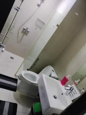 a bathroom with a toilet and a sink at Drew Condotel Across Airport Terminal 3 in Manila