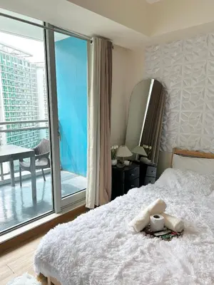 a bedroom with a bed and a large window at M&M Azure Staycation Parañaque in Manila