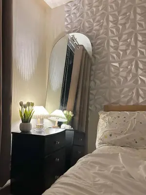 a bedroom with a dresser with a mirror and a bed at M&M Azure Staycation Parañaque in Manila