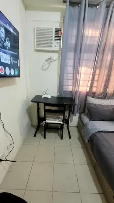 a desk in a room with a bed and a window at Richard's Pad in Manila