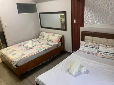 a bedroom with two twin beds and a mirror at Ezekiel's Suites in Manila