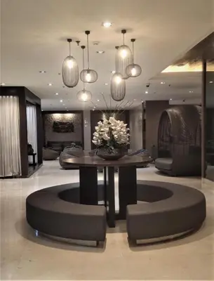 a lobby with a table and chairs and lights at BIG CUT, END UNIT in SHORE RESIDENCES in Manila