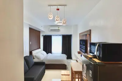 a hotel room with a bed and a living room at Modern Lux at Shore 3 Tower 4 SMDC Pool View in Manila