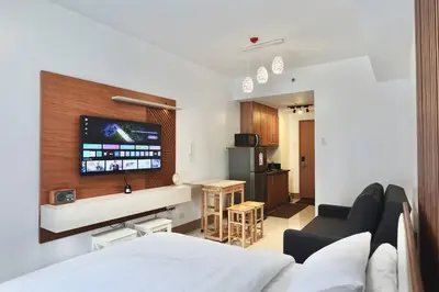 a room with a bed and a living room with a tv at Modern Lux at Shore 3 Tower 4 SMDC Pool View in Manila
