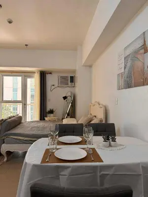 a living room with a table with plates and wine glasses at Venice Vista Lodge Staycation connected to Venice Grand Canal in Manila