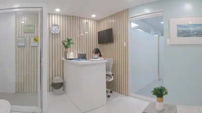 a woman sitting at a counter in a room at Cedar House in Manila