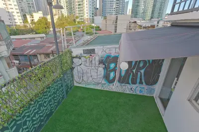 a balcony with green grass and a wall with graffiti at Cedar House in Manila