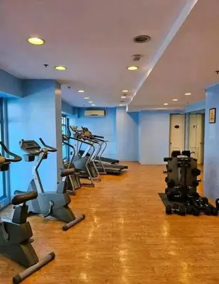 a gym with rows of tread machines in a room at Newly Renovated 2-Storey Loft at Greenbelt 1 in Manila