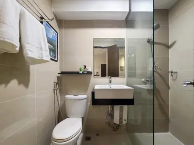 a bathroom with a toilet and a sink and a shower at Vintage Mickey Disney Stay in BGC -200mbps wifi in Manila