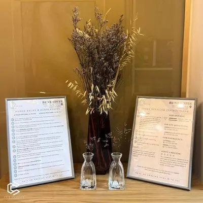 a table with two certificates and a vase with flowers at Crib2Go Benz Suite with Pool View in Manila