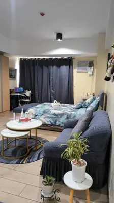 a living room with a couch and a bed at Studio Type Condotel at Venice McKinley Taguig City in Manila