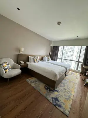 a bedroom with a bed and a chair and a window at The Metro Zen at Hotel Residences Acqua - Novotel Tower in Manila