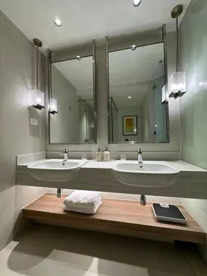 a bathroom with two sinks and a large mirror at The Metro Zen at Hotel Residences Acqua - Novotel Tower in Manila